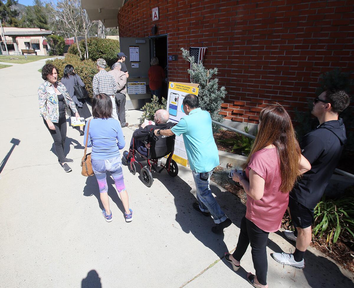 Voters queue up outside the voting center at the La Cañada Unified School District on Election Day for the presidential primary on Tuesday. Some reported wait times of up to 90 minutes.