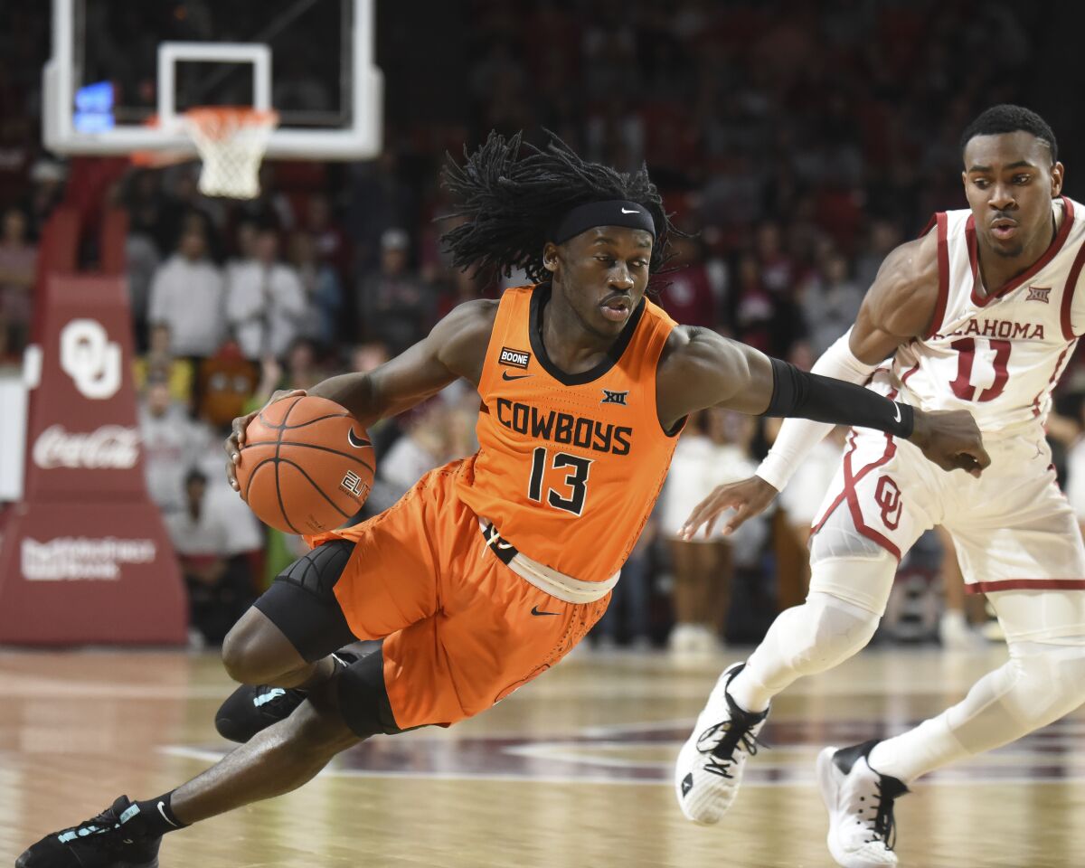 FILE - In this Feb. 1, 2020, file photo, Oklahoma St. guard Isaac Likekele, left, pushes past Oklahoma guard De'Vion Harmon, right, during the first half of an NCAA college basketball game in Norman, Okla. Likekele, a junior guard, was Oklahoma State’s No. 2 scorer last season with 10.9 points per game. (AP Photo/Kyle Phillips, File)