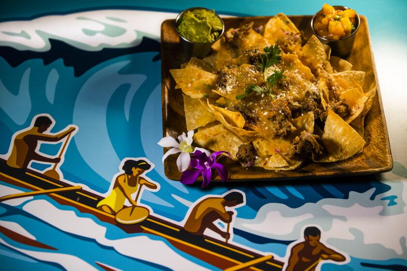 WAIKOLOA VILLAGE,HAWAII-SEPTEMBER 9, 2019: Kalua pork nachos, $19, is on the menu at Kona Tap Room, located inside the Hilton Waikoloa Village in Waikoloa Village, Hawaii. Ingredients are corn chips, fresh jalapeo, red onions, cilantro, kale pork, cotija & monterey jack cheese, guacamole, and tropical salsa. (Mel Melcon/Los Angeles Times)