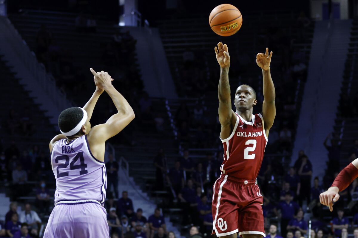 Oklahoma guard Umoja Gibson (2) shoots a 3-point basket as Kansas State guard Nijel Pack (24) defends during the first half of an NCAA college basketball game on Saturday, March 5, 2022 in Manhattan, Kan. (AP Photo/Colin E. Braley)