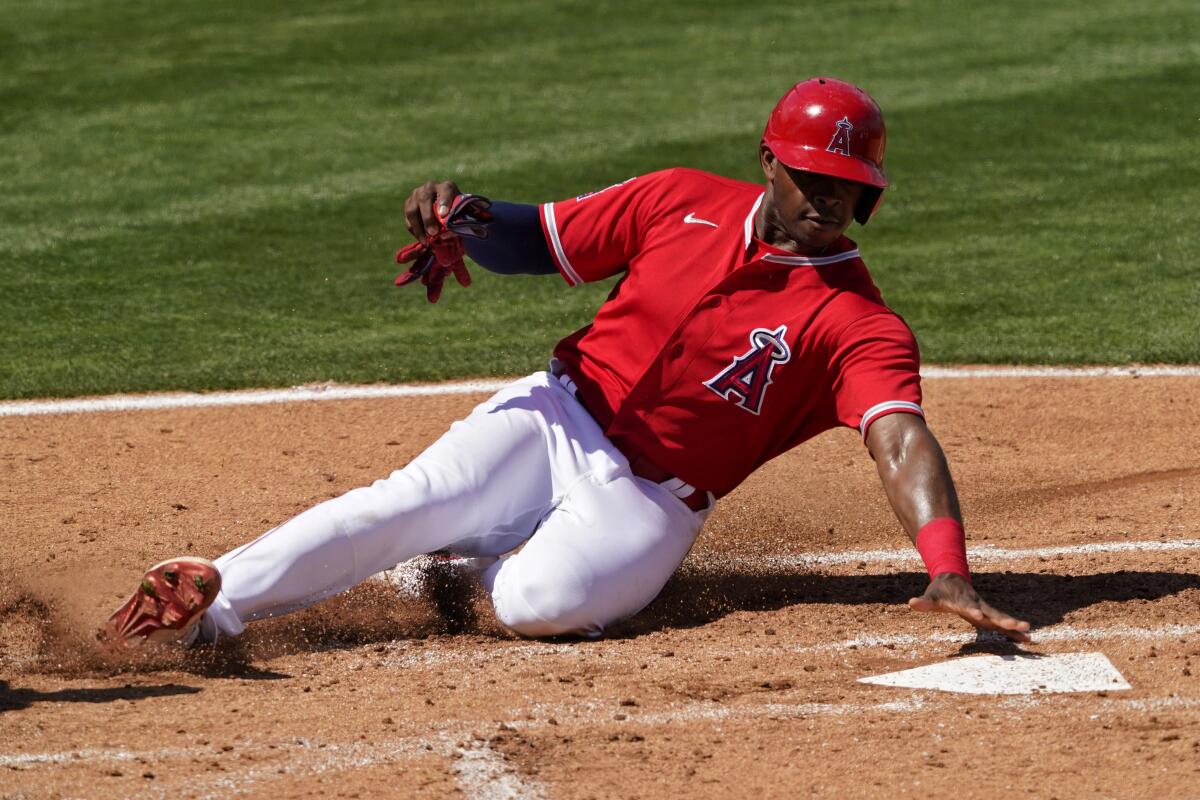 Angels outfielder Justin Upton slides into home plate to score on a hit by Kurt Suzuki.