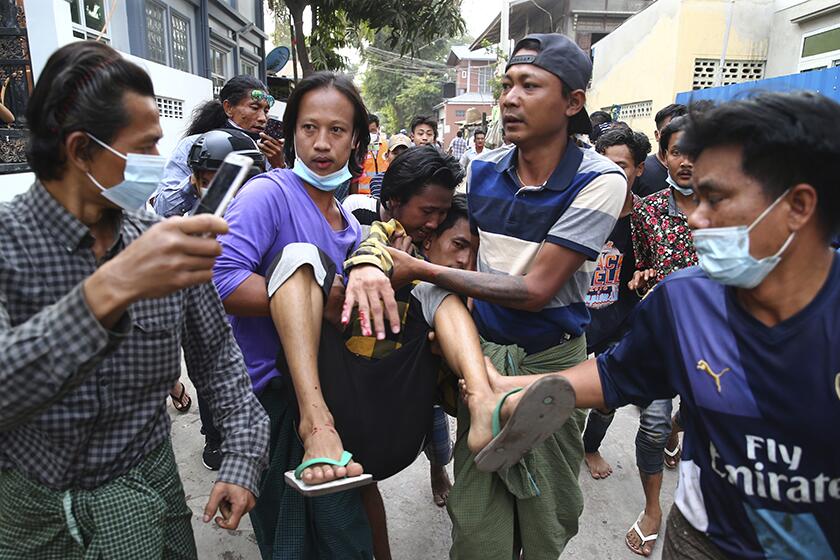 An injured man is carried to safety after police dispersed anti-coup protesters in Mandalay, Myanmar,on Saturday