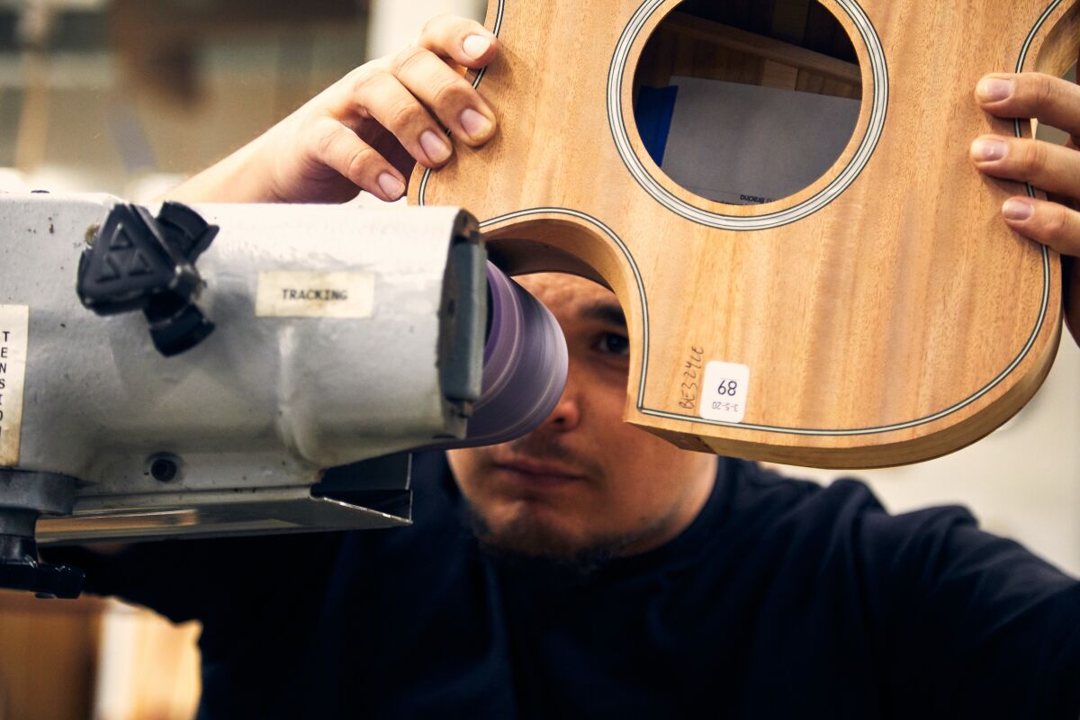 At Taylor Guitars' El Cajon facility, Clinton Jackson works on a guitar made out of urban wood.