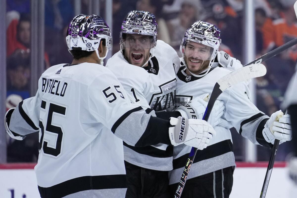 Kings captain Anze Kopitar celebrates with Quinton Byfield, left, and Matt Roy after scoring against the Flyers.