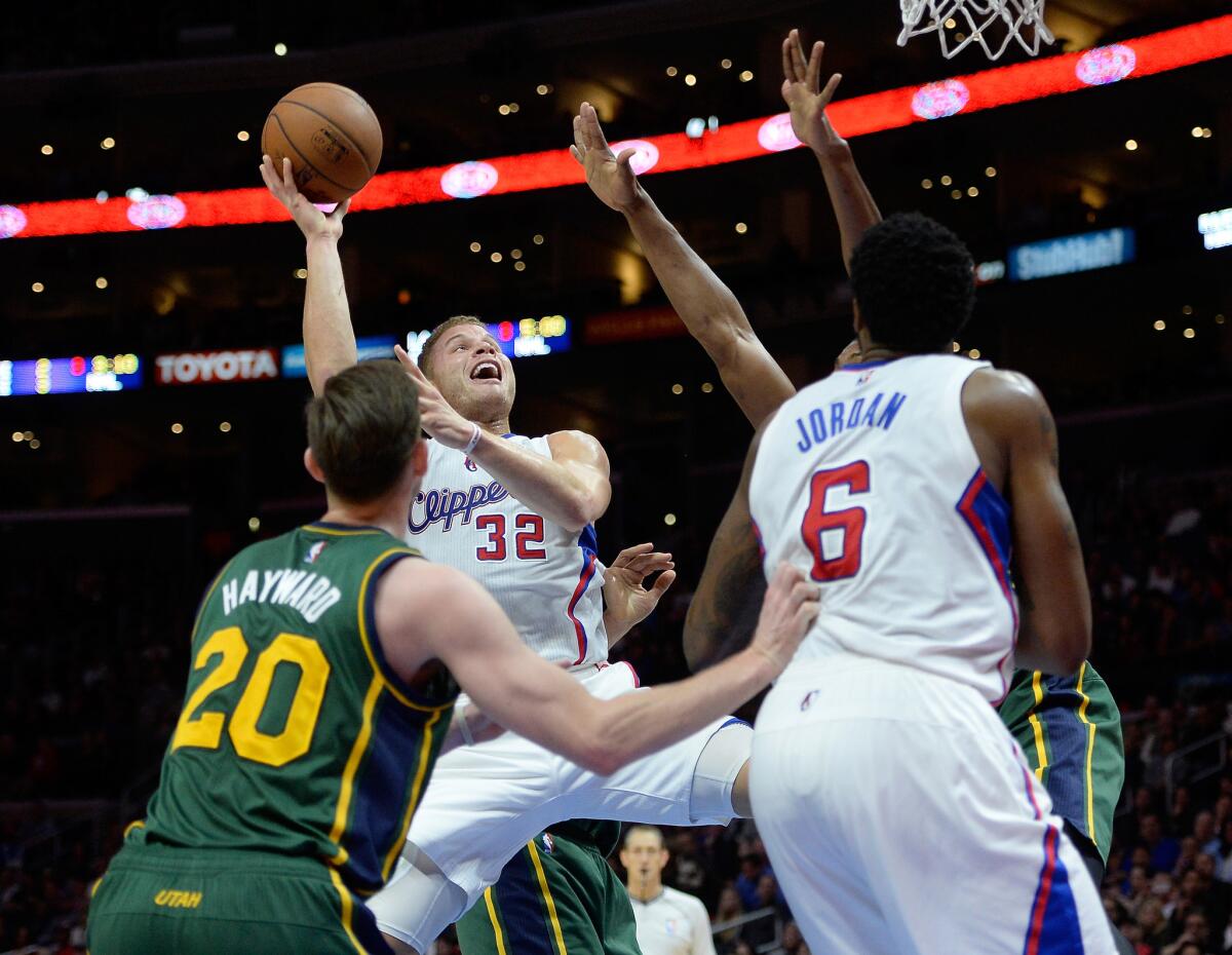 Clippers forward Blake Griffin takes a shot as he's fouled by Jazz forward Derrick Favors (partially hidden by Clippers center DeAndre Jordan) in the first half.