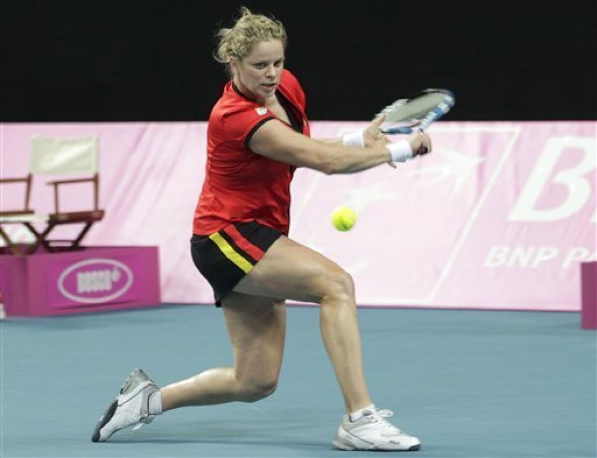 Belgium's Kim Clijsters returns the ball to US player Melanie Oudin during the World Group Fed Cup match in Antwerp, Belgium, Saturday, Feb. 5, 2011. Belgium leads on the first day 2-0. (AP Photo/Yves Logghe)