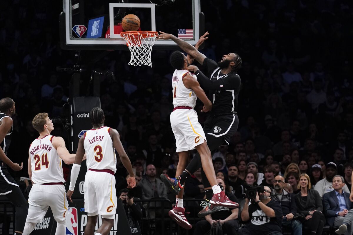 Brooklyn Nets' Andre Drummond, right, tries to dunk over Cleveland Cavaliers' Evan Mobley during the first half of the opening basketball game of the NBA play-in tournament Tuesday, April 12, 2022, in New York. (AP Photo/Seth Wenig)
