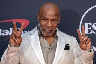 Mike Tyson gives peace signs with both hands as he arrives on the red carpet at the 2023 ESPY Awards.