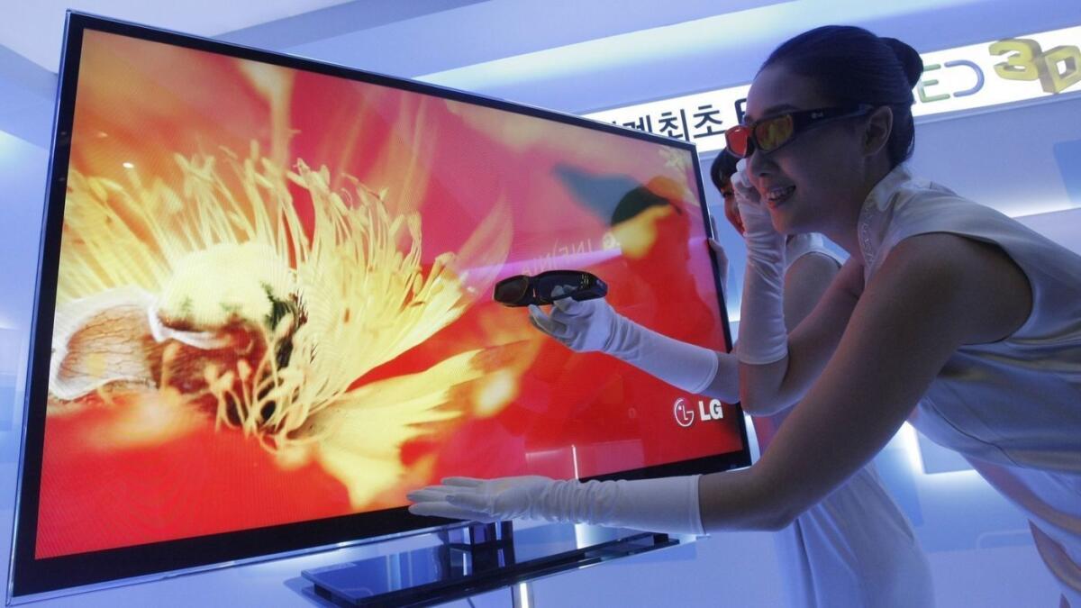 Una modelo ayuda a presentar la televisión LED 3D de LG Electronics en Seúl en marzo de 2010. La compañía de electrónica lanzará un televisor de “pantalla enrollable” de 65 pulgadas el próximo año.