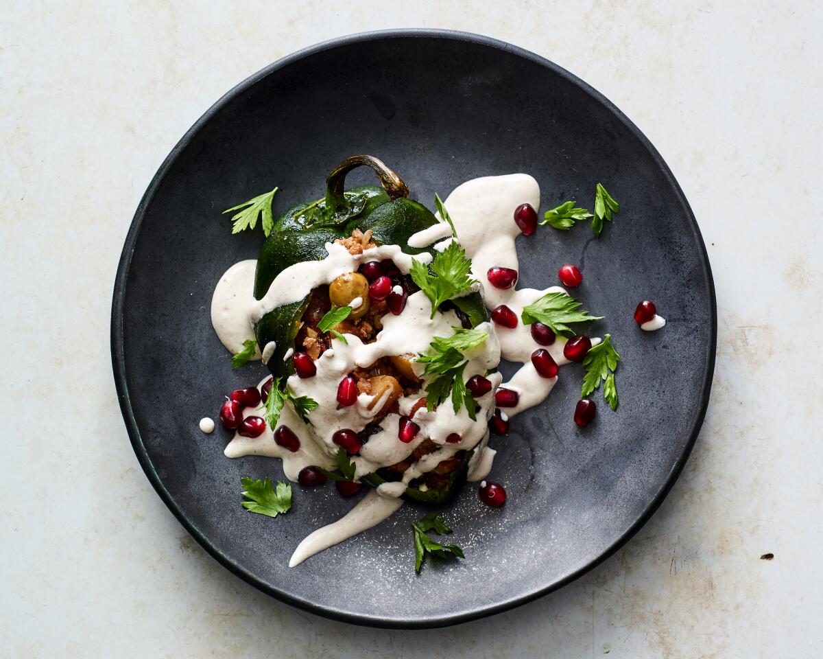 The Mexican dish Chiles en Nogada — stuffed poblano peppers topped with a creamy walnut sauce and pomegranate seeds.