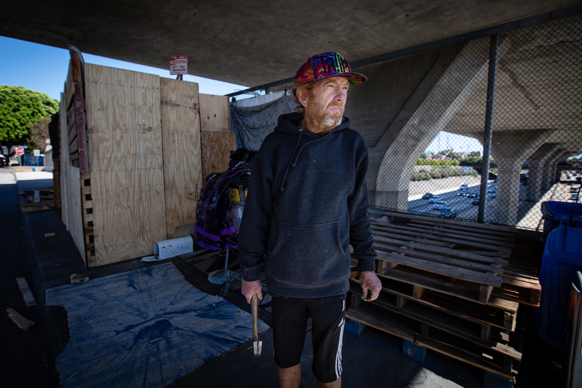 Kenny Welch stands in front of his living structure on a 110 Freeway overpass.