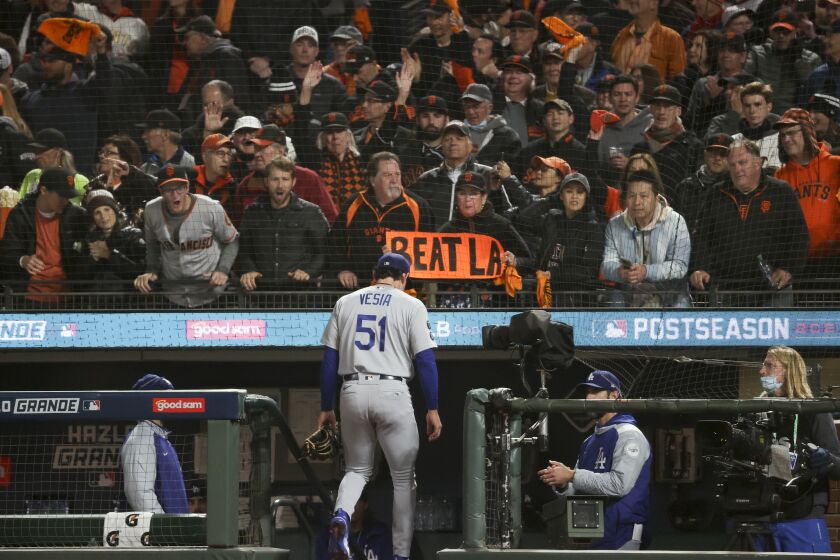 San Francisco, CA - October 08: San Francisco Giants fans hold signs and cheer while Los Angeles Dodgers relief pitcher Alex Vesia leaves the game during the eighth inning at Oracle Park on Friday, Oct. 8, 2021 in San Francisco, CA. (Robert Gauthier / Los Angeles Times)