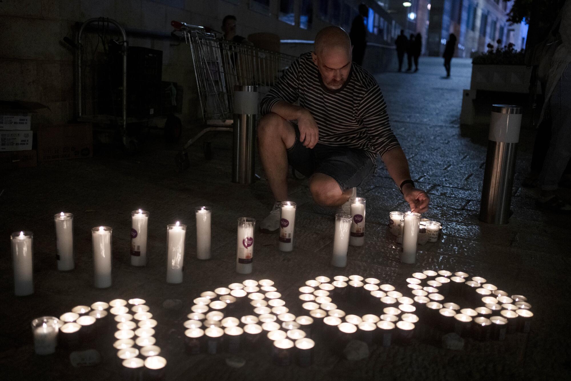 Man lighting candles, some grouped to form the number 1,400 
