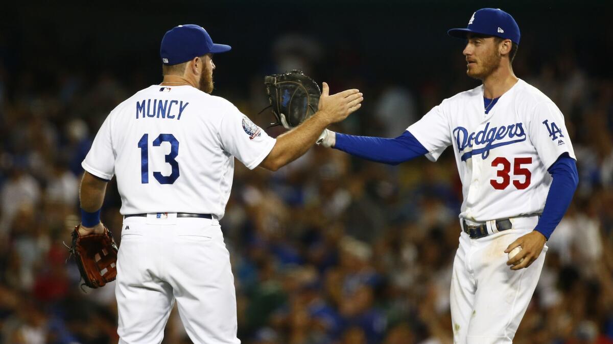 Dodgers first baseman Max Muncy (13) and first baseman Cody Bellinger (35) congratulate each other after defeating the Angels at Dodger Stadium on Friday.