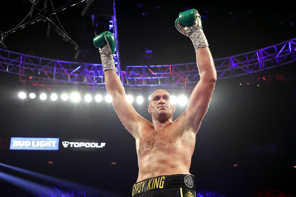 Tyson Fury celebrates after knocking down Deontay Wilder during their WBC heavyweight title fight 