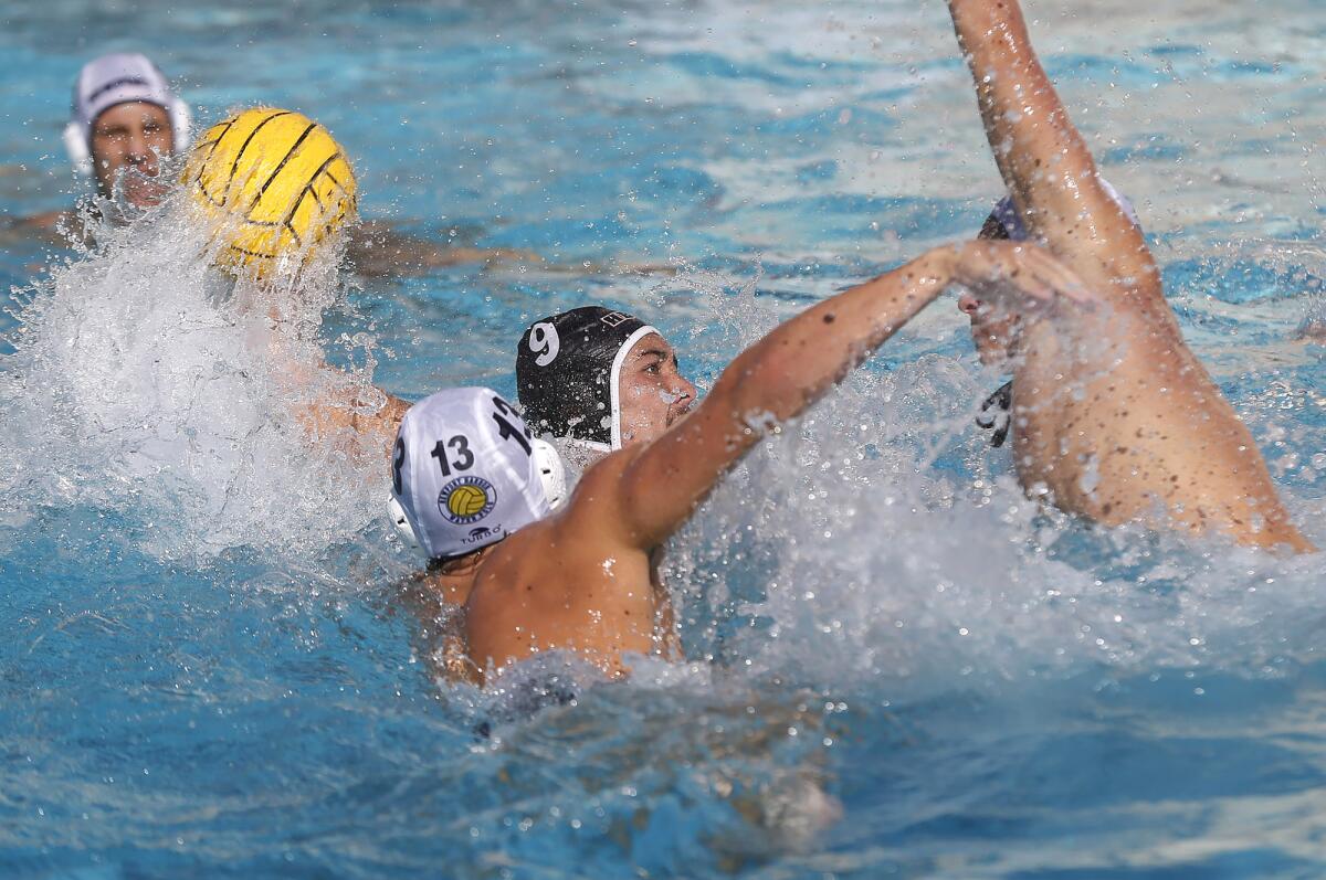 Ethan Spoon (9) of Huntington Beach shoots and scores as defenders surround him during Wednesday's Surf League match.