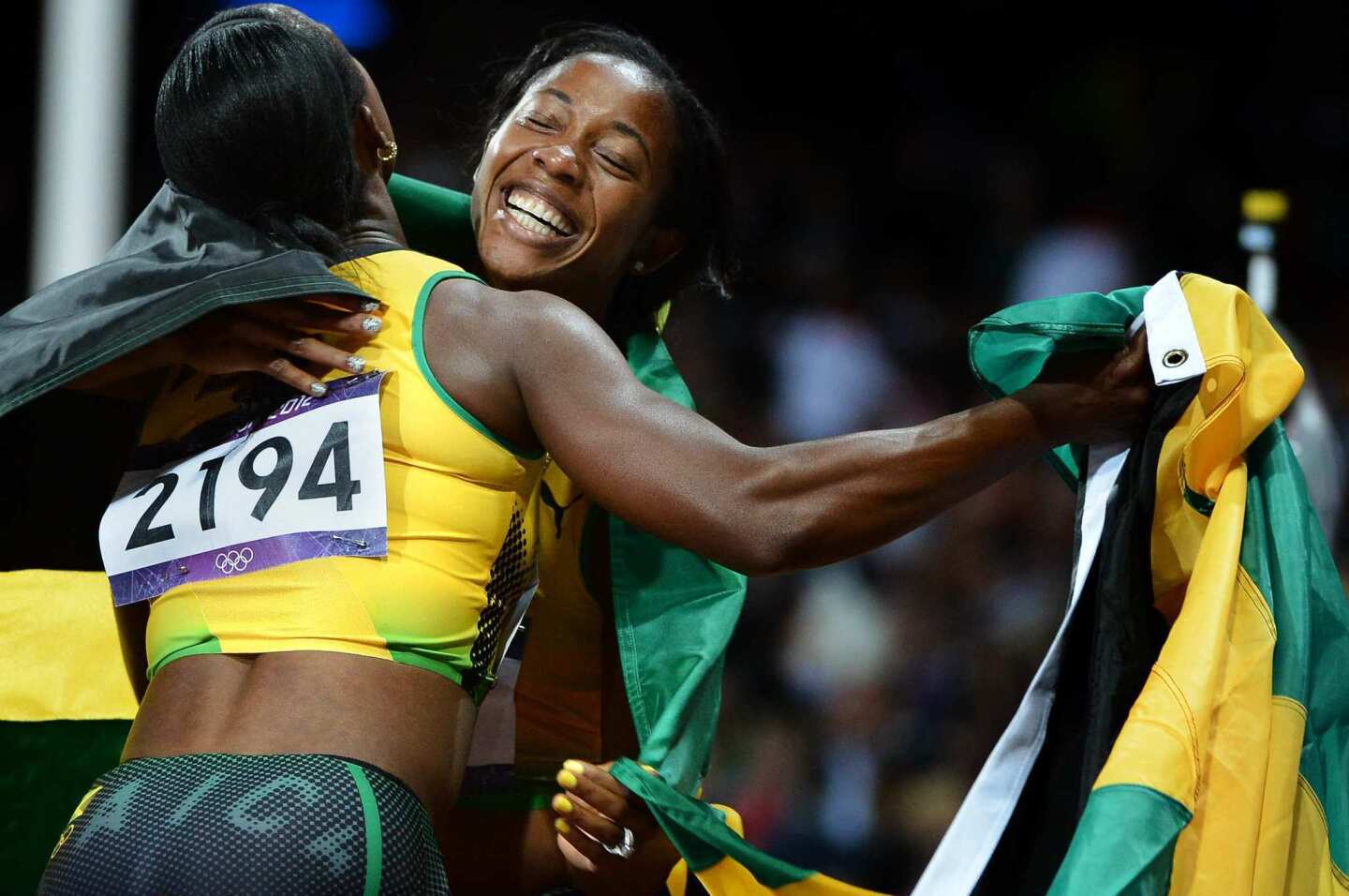 Gold medal winner Shelly-Ann Fraser-Pryce, right, and bronze medal winner Veronica Campbell-Brown embrace after the 100-meter finals. Both are from Jamaica.