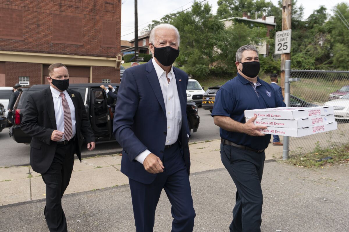 Democratic presidential candidate Joe Biden arrives with pizza as he visits firefighters in Pittsburgh in August.