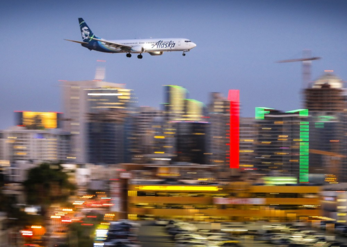 An airplane flies by downtown San Diego
