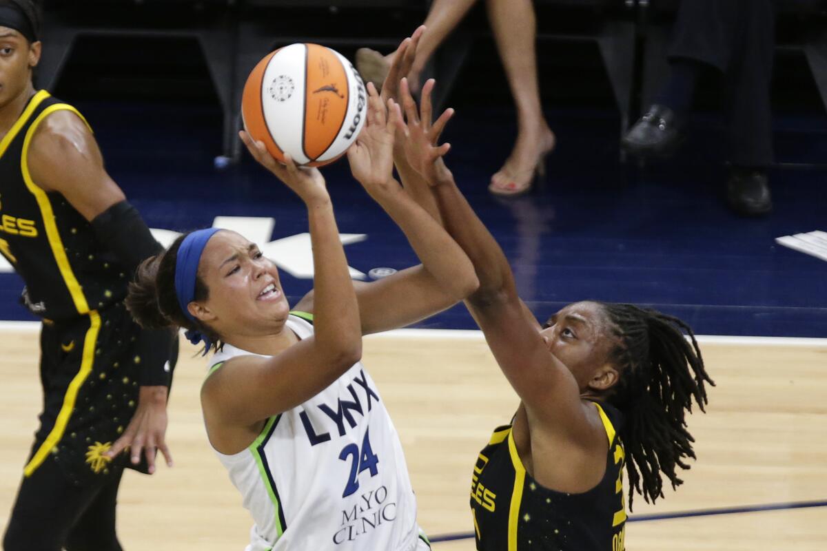 Minnesota Lynx forward Napheesa Collier (24) shoots over Los Angeles Sparks forward Nneka Ogwumike during the fist quarter of a WNBA basketball game Thursday Sept. 2, 2021 in Minneapolis. (AP Photo/Andy Clayton-King)