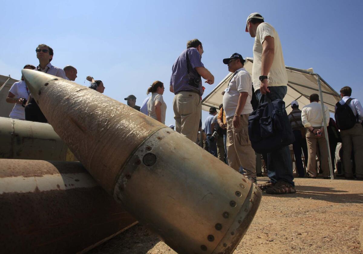 Activists and international delegations stand next to cluster bombs on display in 2011 in Lebanon