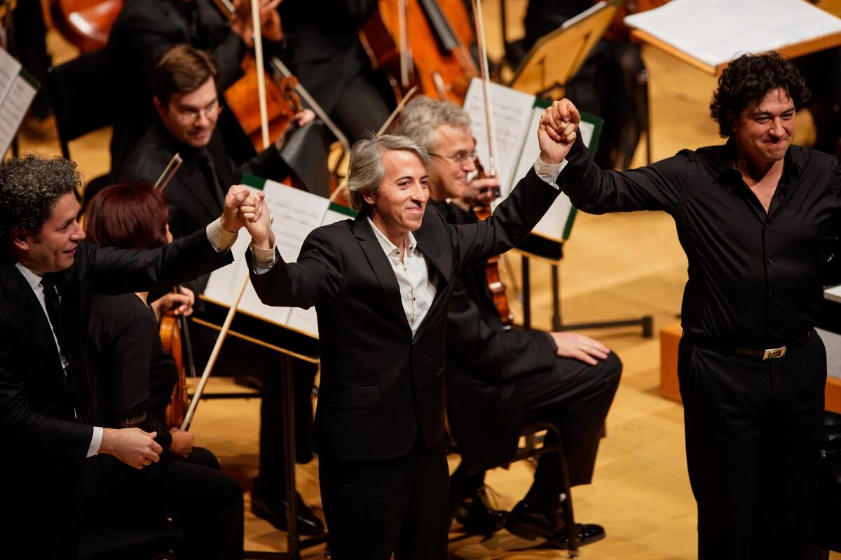 Gustavo Dudamel, left, composer Esteban Benzecry and pianist Sergio Tiempo take a bow Thursday.