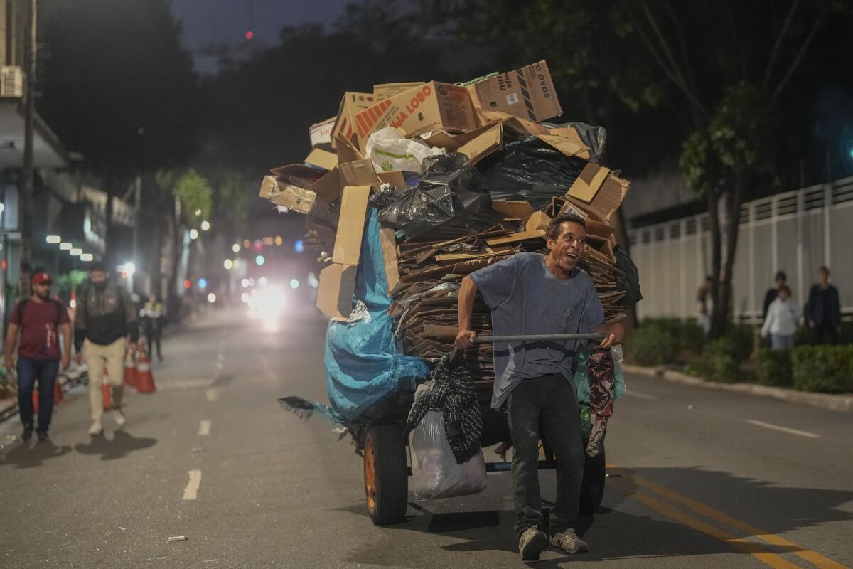 Un hombre tira de un carrito de artículos reciclables para vender en el centro de Sao Paulo, Brasil, 