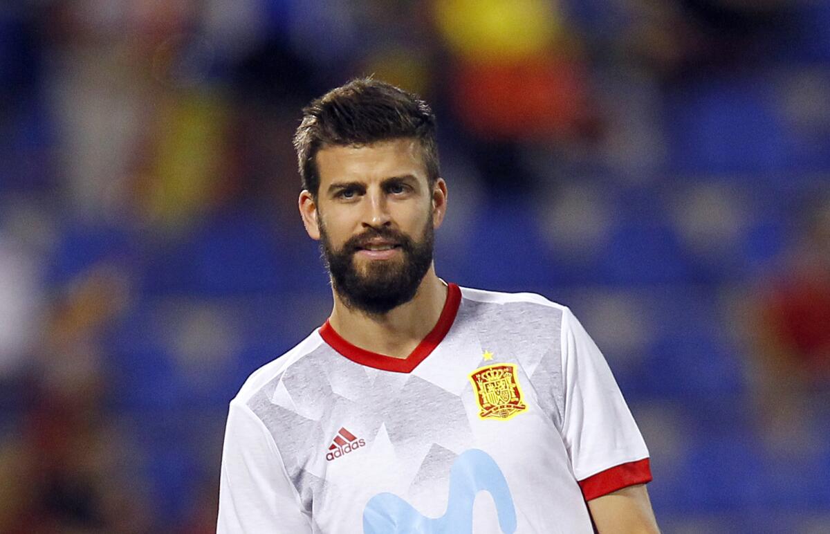 A man with brown hair and facial hair in a soccer jersey.