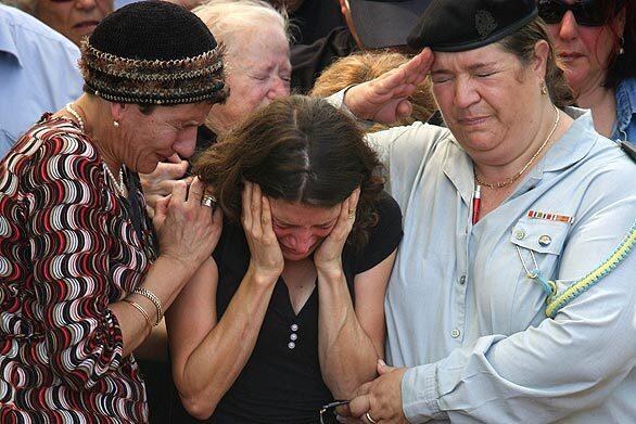 Karnit Goldwasser, the widow of Israeli soldier Ehud Goldwasser, mourns at her husband's wreath-covered grave during his funeral Thursday in the northern Israeli border town of Nahariya. The bodies of Goldwasser and fellow soldier Eldad Regev were returned to Israel the day before as part of a prisoner exchange with the Lebanese Islamic group Hezbollah two years and four days after they were captured in a cross-border raid that led to the 2006 Lebanese War.