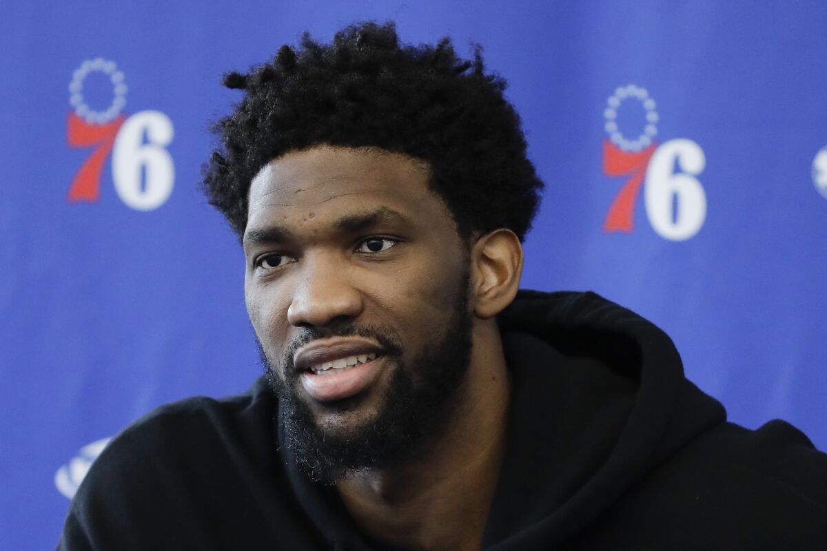 FILE - Philadelphia 76ers' Joel Embiid speaks with members of the media during a news conference at the NBA basketball team's practice facility in Camden, N.J., in this Monday, May 13, 2019, file photo. Knocked his entire career for conditioning woes, Embiid dedicated his offseason to a fitness program he vowed would keep him with the 76ers. Embiid kept his personal transaction wire humming in the shortened offseason with the additions of a personal chef, nutritionist, physical therapist and a massage therapist to shape the 6-foot-11 center into MVP form.(AP Photo/Matt Rourke, File)
