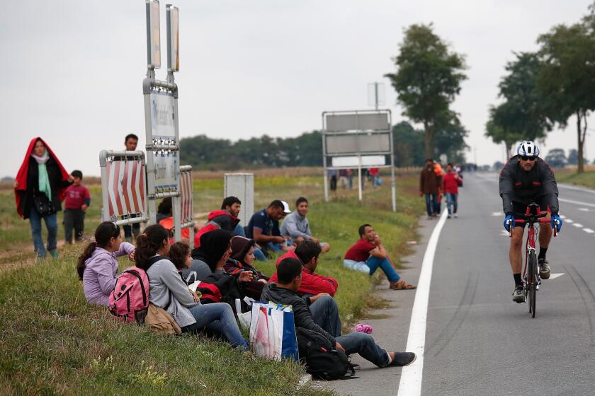 Migrants rest near Nickelsdorf, Austria, after setting off on foot after Austrian authorities suspended train service at the border with Hungary on Friday.