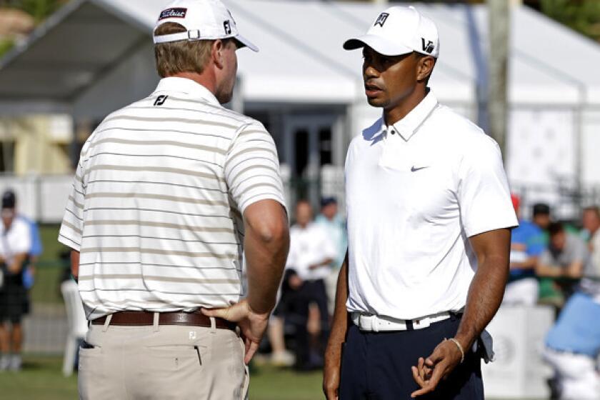 Tiger Woods talks to Steve Stricker on the practice putting green at Doral Golf Resort and Spa on Wednesday.