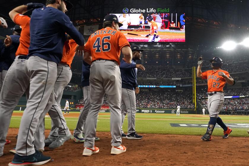 Houston Astros' Jose Altuve (27) celebrates with teammates after hitting a three-run home run against the Texas Rangers during the ninth inning in Game 5 of the baseball American League Championship Series Friday, Oct. 20, 2023, in Arlington, Texas. (AP Photo/Julio Cortez)