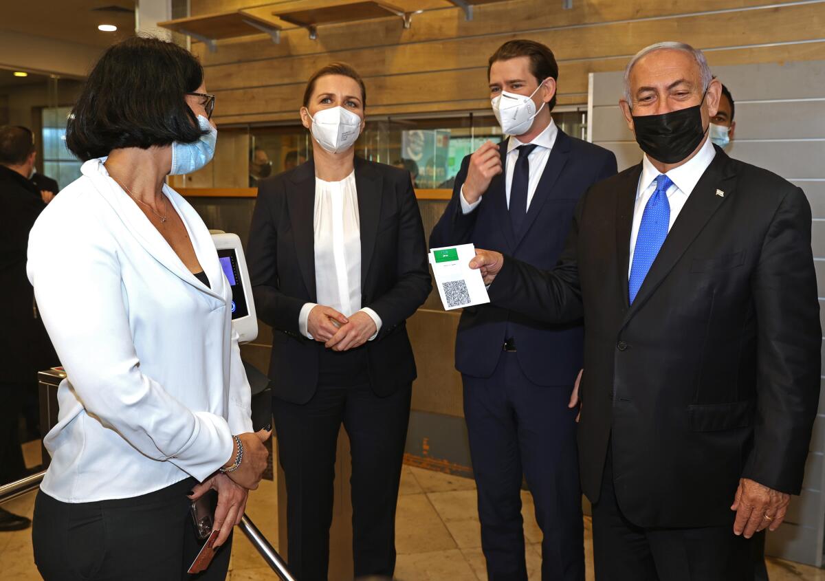 Then-Israeli Prime Minister Benjamin Netanyahu holding COVID vaccine pass