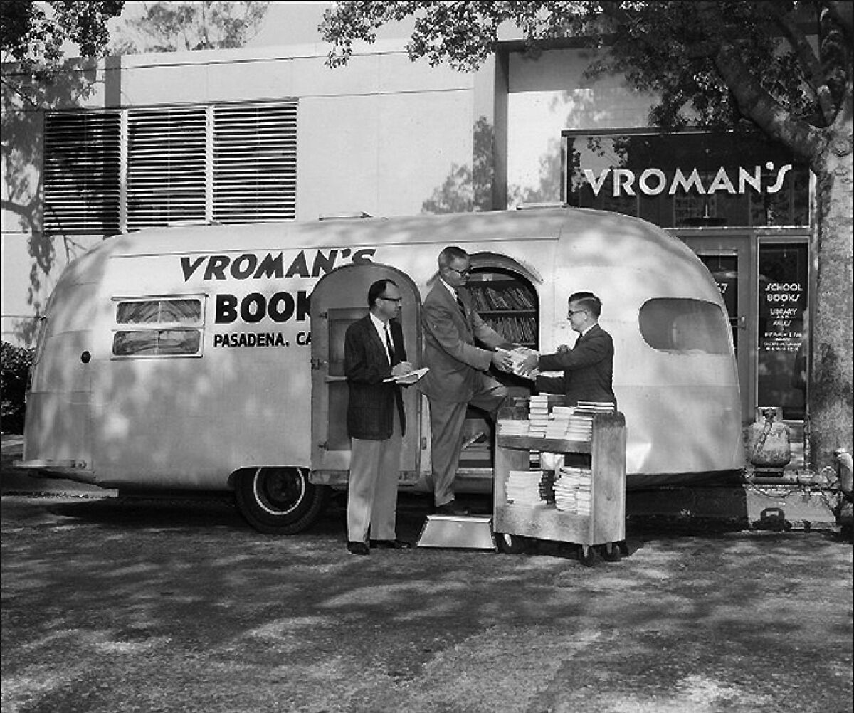 Men buying and selling books out of a bookmobile.