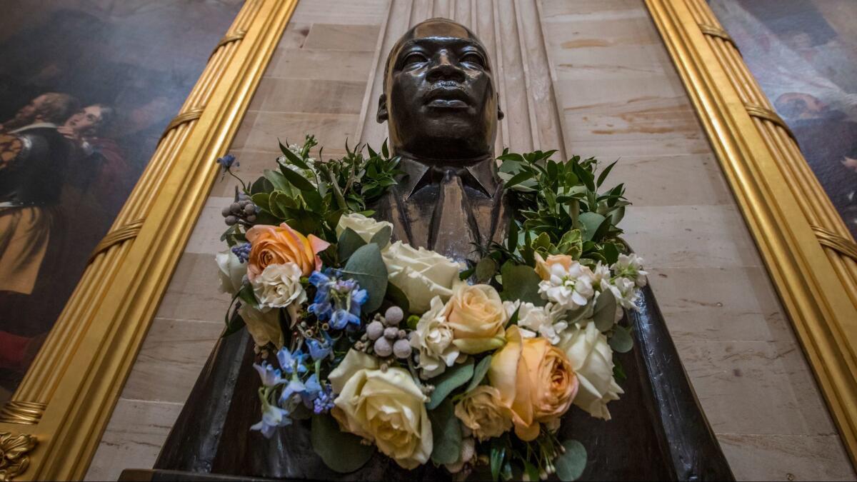 The bust of civil rights activist and leader Martin Luther King Jr. is draped with a wreath of flowers in the Capitol Rotunda in Washington on Jan. 11.