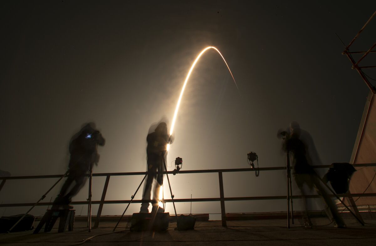 Photographers follow a SpaceX Falcon 9 rocket during a time exposure as it lifts off from Launch Complex 39A at the Kennedy Space Center in Cape Canaveral, Fla., Thursday, Dec. 9, 2021. The Falcon 9 will deploy into orbit NASA's Imaging X-ray Polarimetry Explorer (IXPE) spacecraft, an X-ray astronomy mission to study black holes and neutron stars.(AP Photo/John Raoux)
