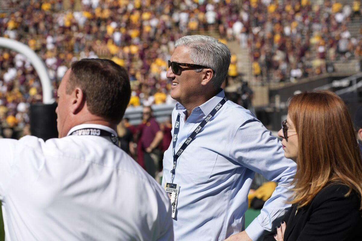 Pac-12 commissioner George Kliavkoff, center, attends a football game.
