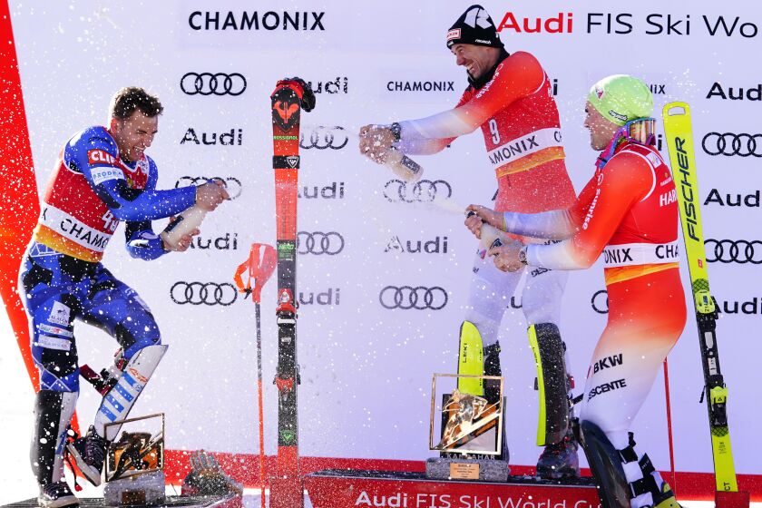 Switzerland's Ramon Zenhaeusern, center, winner of an alpine ski, men's World Cup slalom, celebrates on the podium with second-placed Greece's Aj Ginnis, left, and third-placed Switzerland's Daniel Yule, in Chamonix, France, Saturday, Feb. 4, 2023. (AP Photo/Pier Marco Tacca)