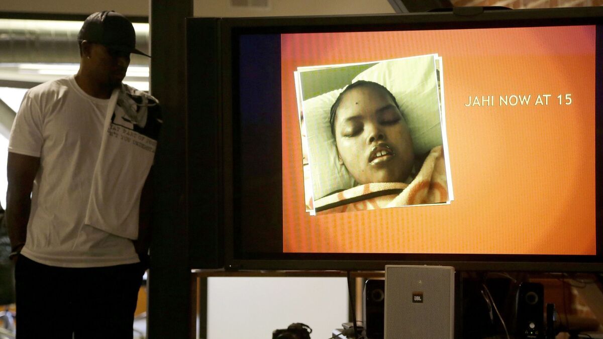 An image of of Jahi McMath is on display as her uncle Timothy Whisenton looks on at a December 2015 news conference in San Francisco.