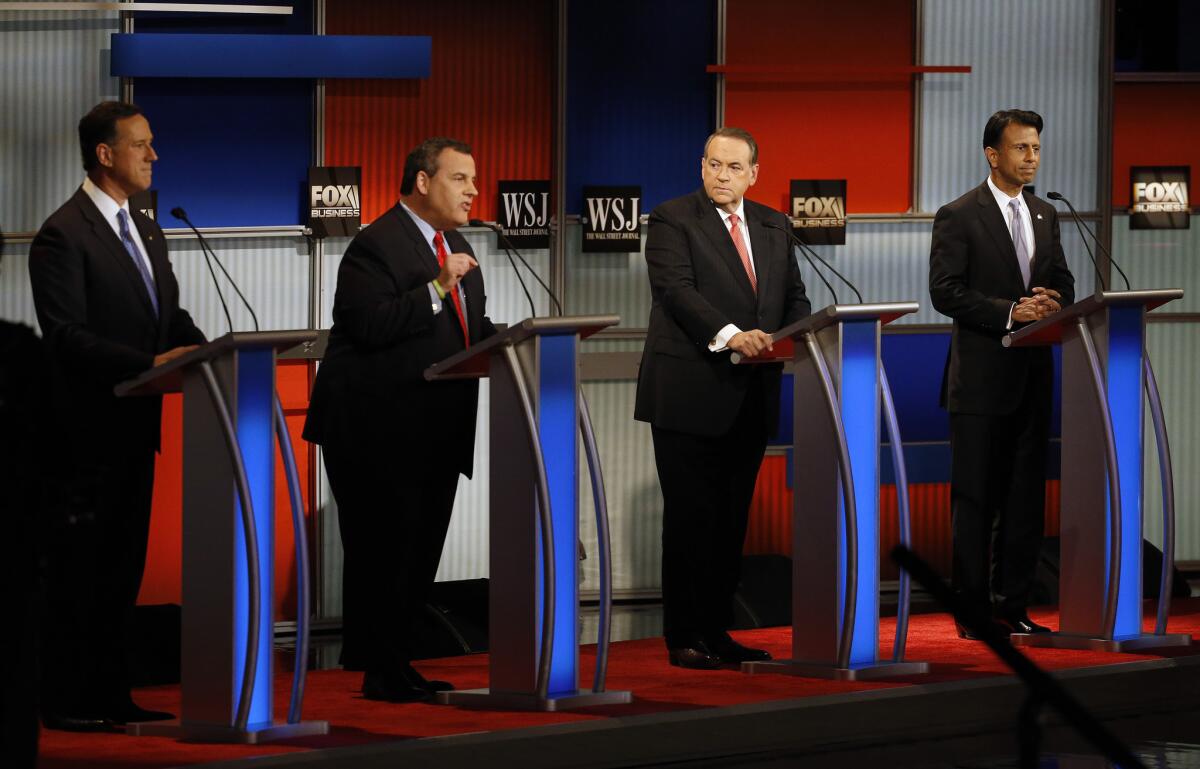 Chris Christie, second from left, speaks as Rick Santorum, left, Mike Huckabee and Bobby Jindal wait during the Republican presidential debate at the Milwaukee Theatre.