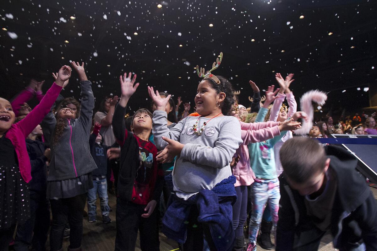 Children react to falling snow during the Mariners Church annual Christmas Tree Lighting on Thursday, December 4.