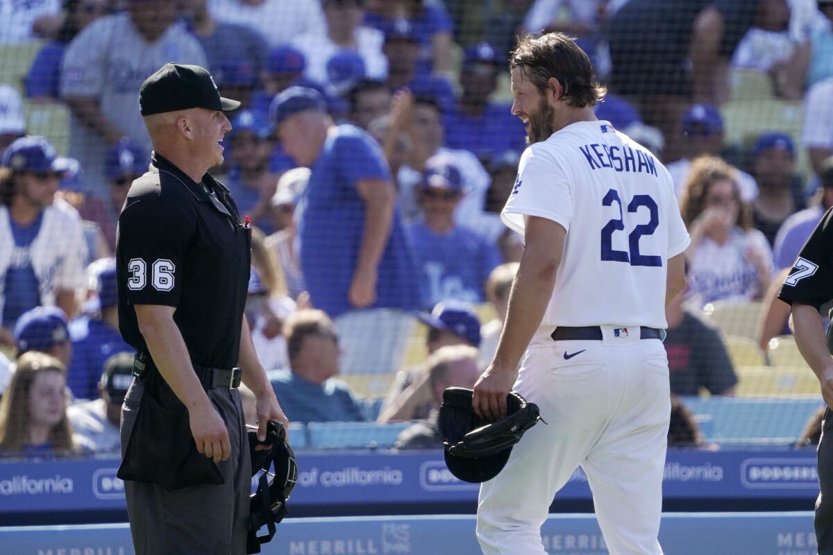 Clayton Kershaw, right, smiles at home plate umpire Ryan Blakney after being checked for "sticky stuff."