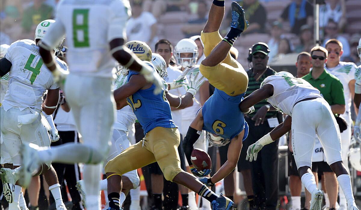 Bruins receiver Jordan Payton is flipped after making a reception against the Ducks in the fourth quarter.