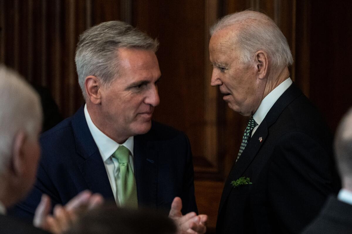 House Speaker Kevin McCarthy talking while President Biden stands next to him