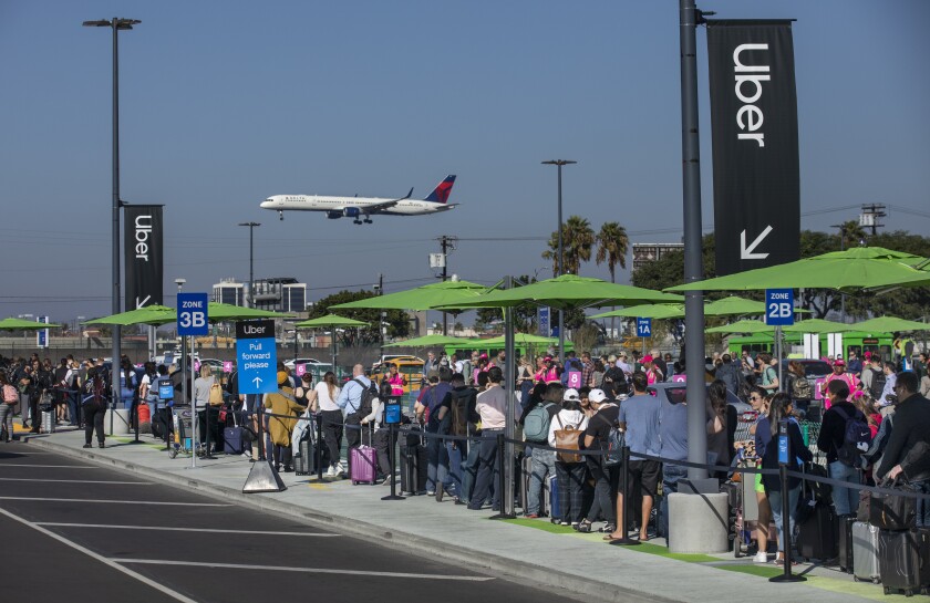 Travelers wait for Uber rides in the new LAX pickup lot 