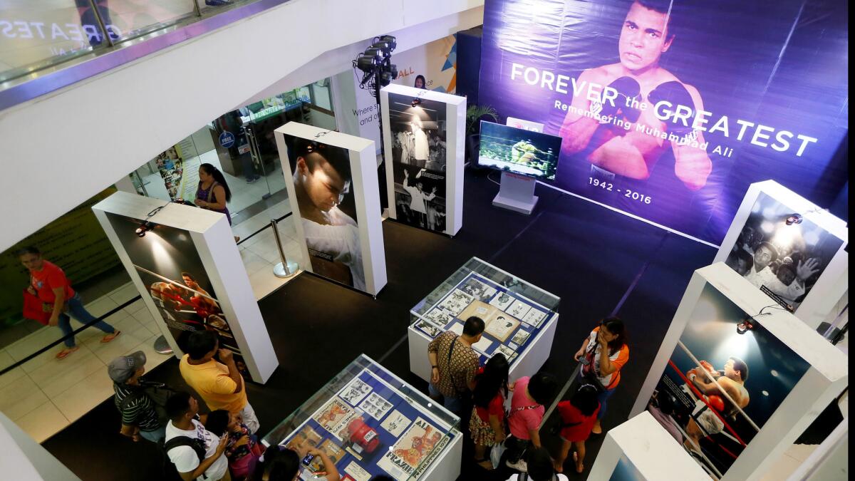 Filipino fans look at memorabilia from the "Thrilla in Manila" fight between Muhammad Ali and Joe Frazier at the launch of an exhibit at the Ali Mall in Manila.