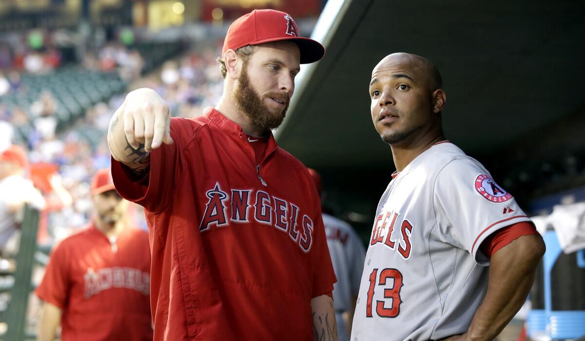 Angels outfielder Josh Hamilton talks with teammate Luis Jimenez (13) in the dugout during a game against the Texas Rangers.
