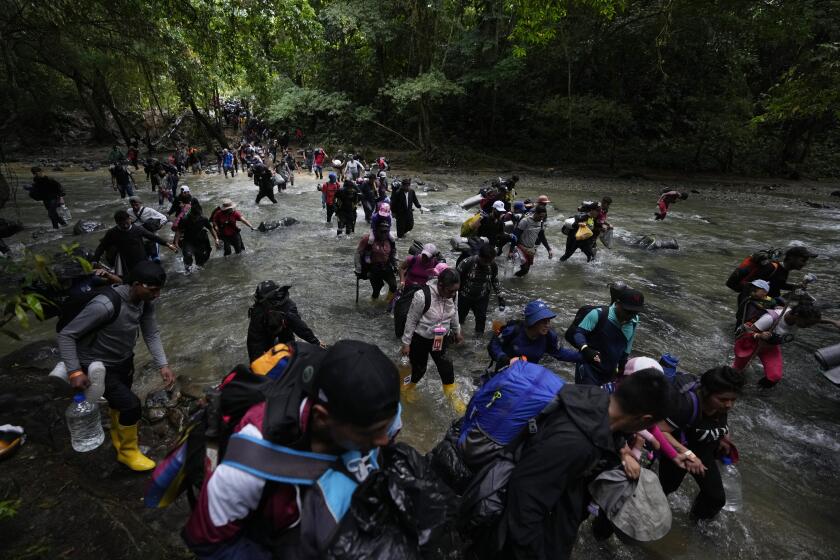 ARCHIVO - Migrantes, en su mayoría venezolanos, cruzan un río durante su viaje a través del Tapón del Darién desde Colombia a Panamá, con la esperanza de llegar a Estados Unidos, el 15 de octubre de 2022. (AP Foto/Fernando Vergara, Archivo)