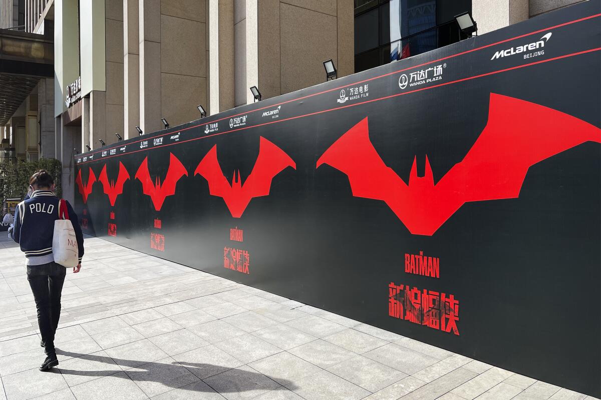 A moviegoer walks by a poster for  'The Batman' at a  Beijing theater